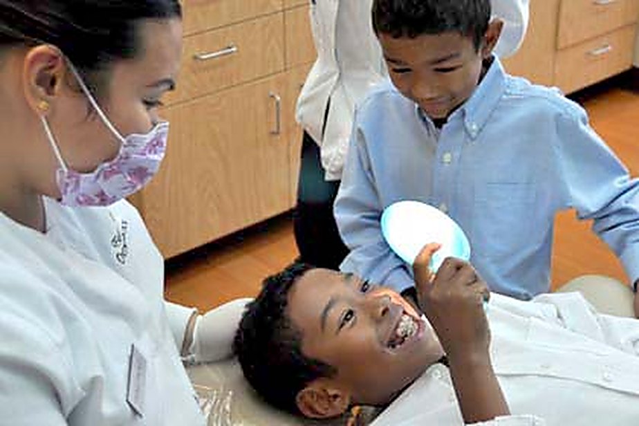 A Family Orthodontics of Dublin assistant showing a young patient his teeth in a hand mirror