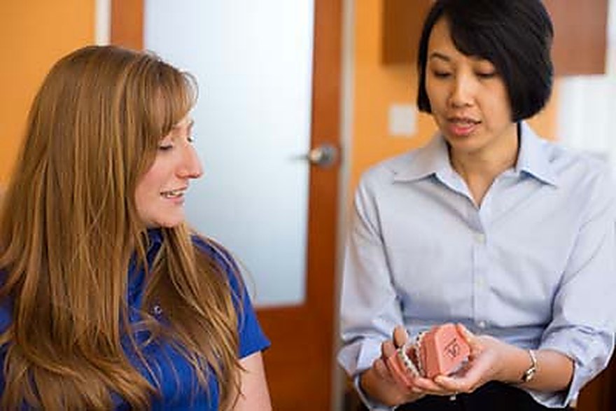 Dr. Hsieh reviewing a dental model with a patient in the consultation room